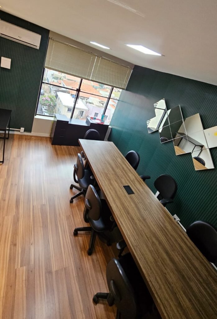 Sala de reunião com mapa-múndi na parede e janela com vista para Piracicaba